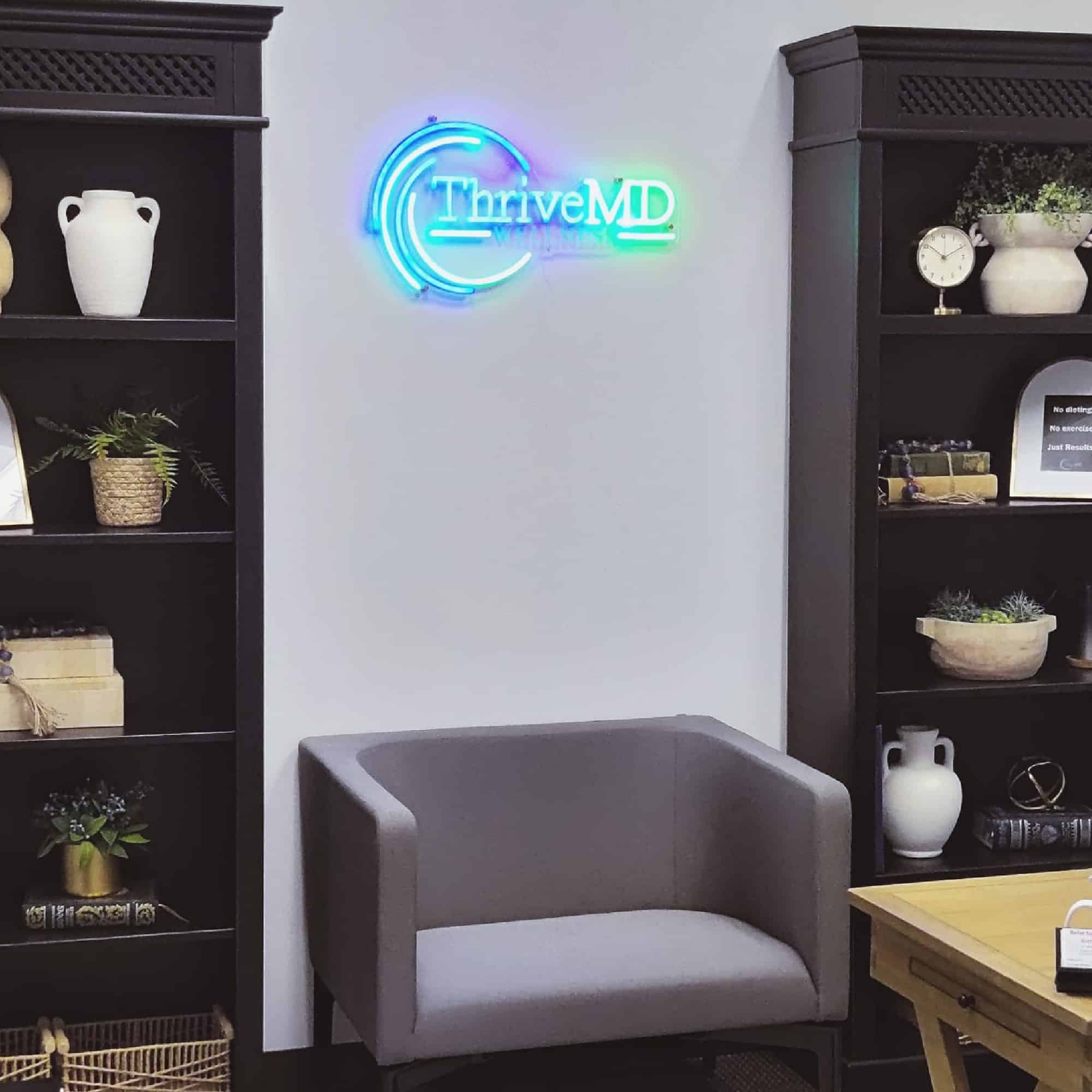 Thrive MD Wellness office interior with neon logo